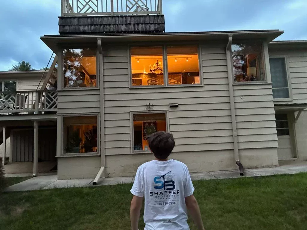 Shaffer Brothers technician inspecting clean upper windows at dusk